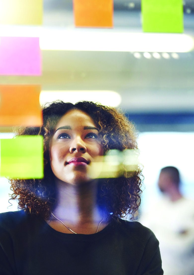 A professional considering ideas arranged on colorful notes during a planning session